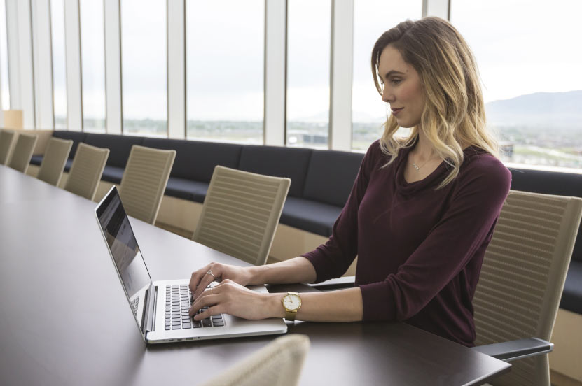 Person Working on Laptop in Conference Room Person Working on Laptop in Conference Room